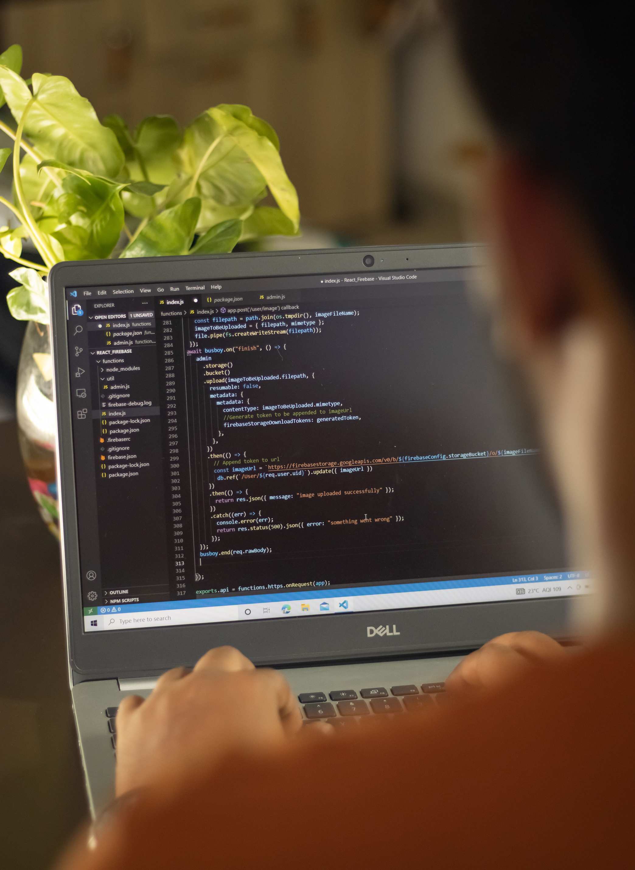 Developer workspace with laptop, person focused on coding